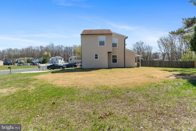 view of side of property featuring a yard and fence