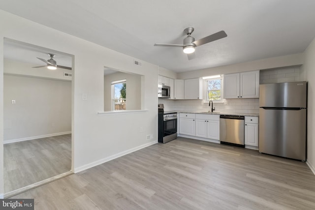 kitchen with stainless steel appliances, visible vents, a sink, and a ceiling fan