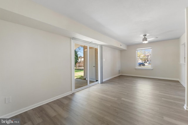 spare room featuring wood finished floors, baseboards, and a ceiling fan