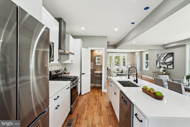 1014 Kearny St NE, Washington, DC 20017 - kitchen featuring a sink, light wood-style floors, wall chimney exhaust hood, stainless steel appliances, and open floor plan