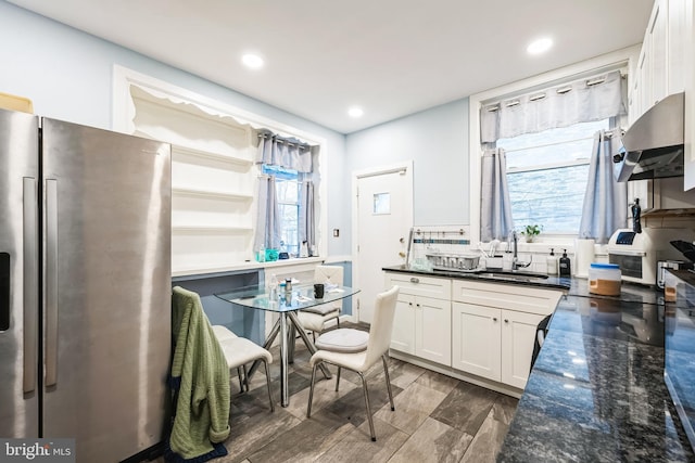 4910 N Hutchinson St, Philadelphia, PA 19141 - kitchen with freestanding refrigerator, wall chimney range hood, white cabinetry, dark stone countertops, and a sink