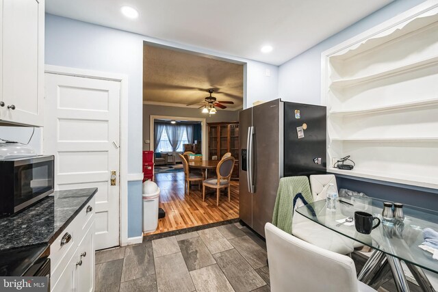 4910 N Hutchinson St, Philadelphia, PA 19141 - kitchen featuring dark stone countertops, ceiling fan, appliances with stainless steel finishes, wood tiled floor, and white cabinetry
