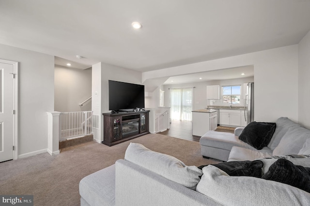 living room featuring light carpet, recessed lighting, and baseboards