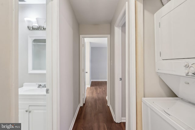 2816 Lee Oaks Pl Unit 102, Falls Church, VA 22046 - hallway with baseboards, stacked washing maching and dryer, dark wood-type flooring, and a sink