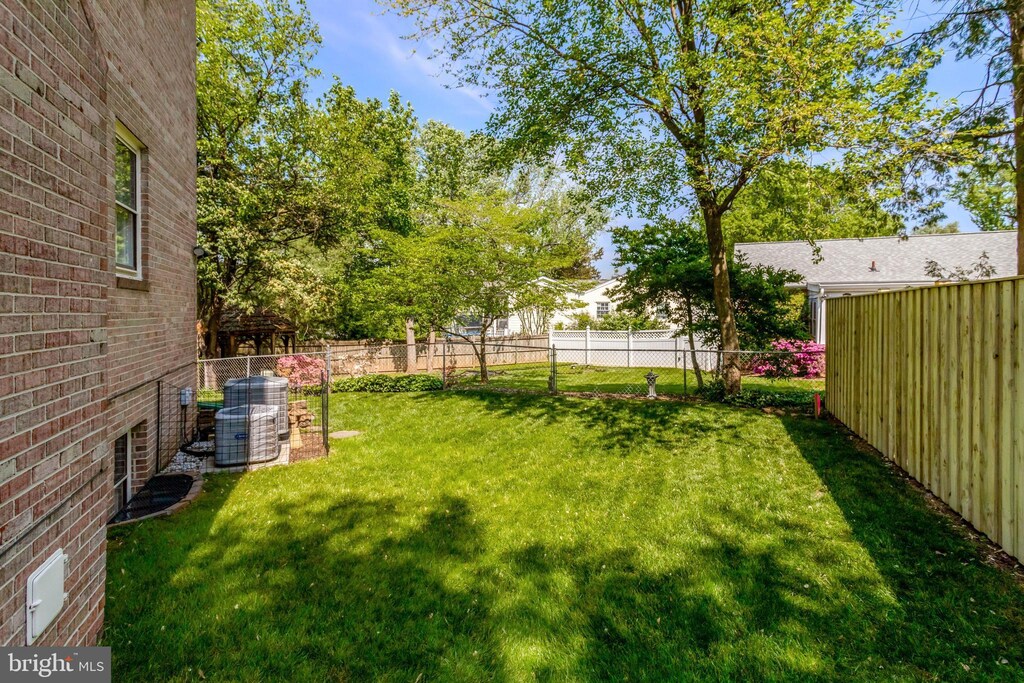 view of yard featuring fence and cooling unit