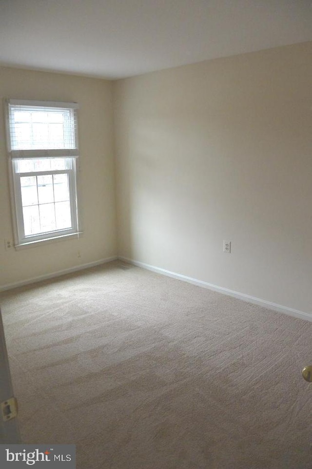 carpeted empty room with baseboards