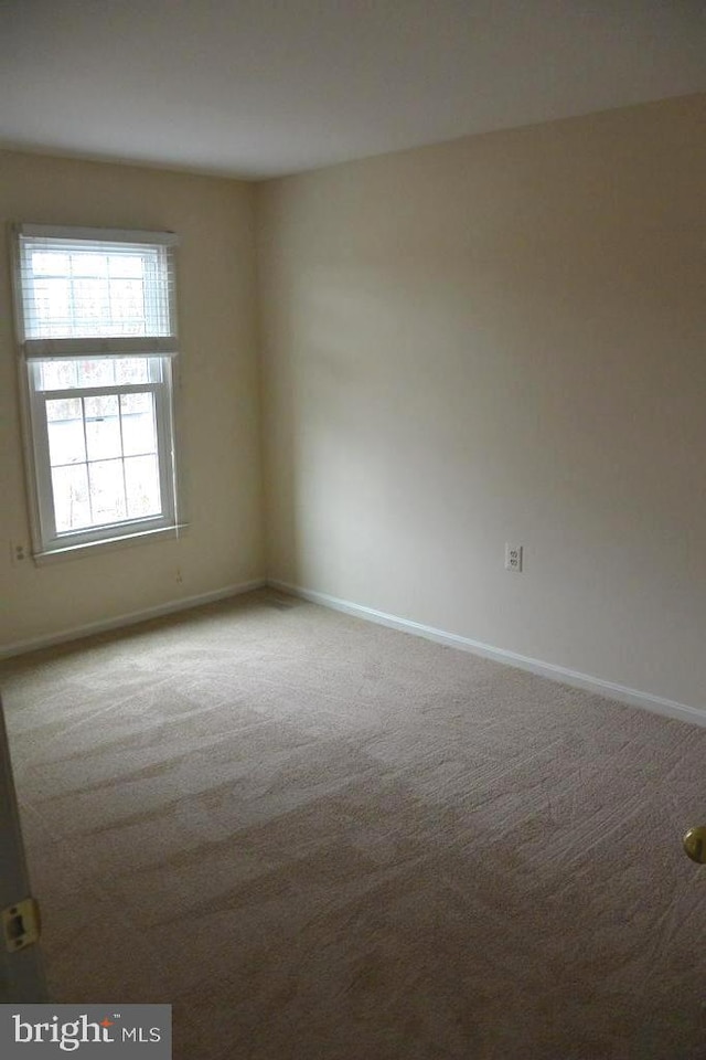 unfurnished room featuring baseboards and carpet