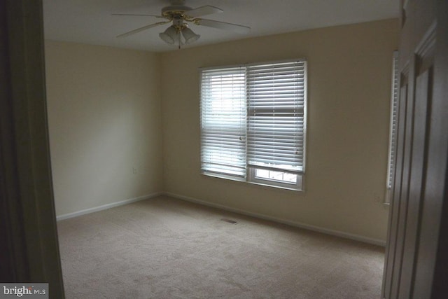 unfurnished room featuring carpet floors, a ceiling fan, and baseboards