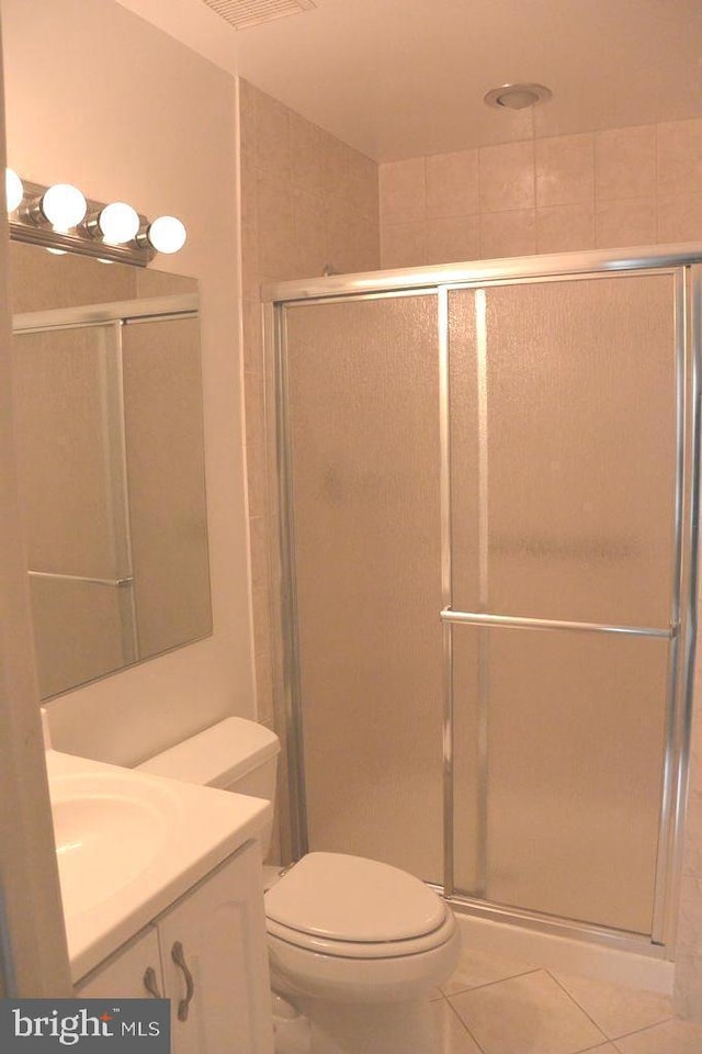 bathroom with vanity, tile patterned flooring, a shower stall, and toilet