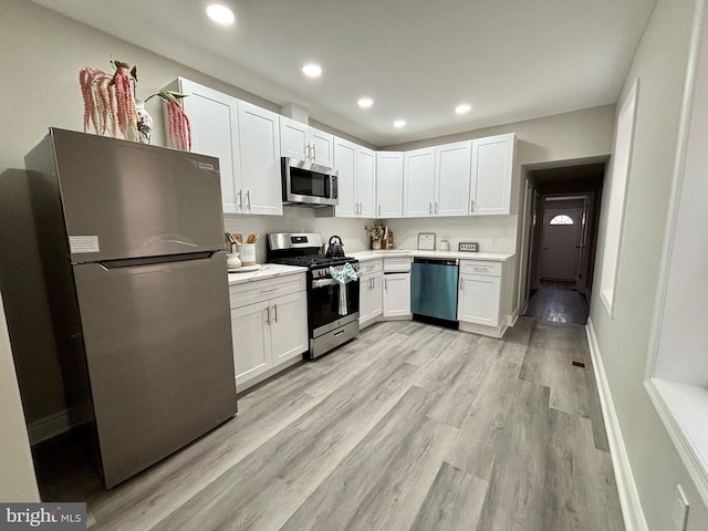 kitchen featuring recessed lighting, white cabinetry, light countertops, stainless steel appliances, and light wood finished floors