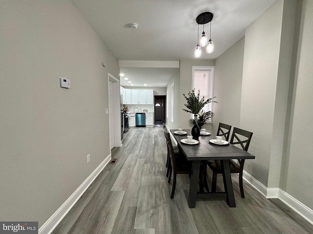 dining space with light wood-type flooring and baseboards