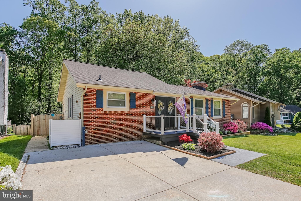 single story home with fence, a front yard, driveway, and brick siding