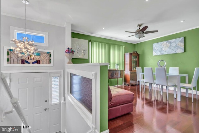 interior space featuring crown molding, baseboards, wood finished floors, and ceiling fan with notable chandelier