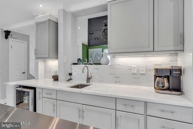 kitchen with a sink, decorative backsplash, wine cooler, and gray cabinetry