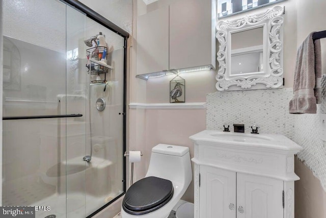 bathroom with a shower stall, vanity, and toilet