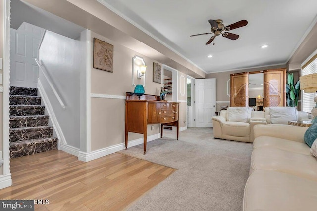 living room with crown molding, light wood-type flooring, a ceiling fan, recessed lighting, and stairway