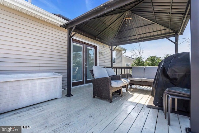 wooden terrace featuring an outdoor living space, grilling area, and a gazebo