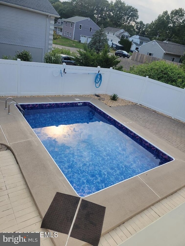 view of swimming pool with a patio, a fenced backyard, a fenced in pool, and a residential view