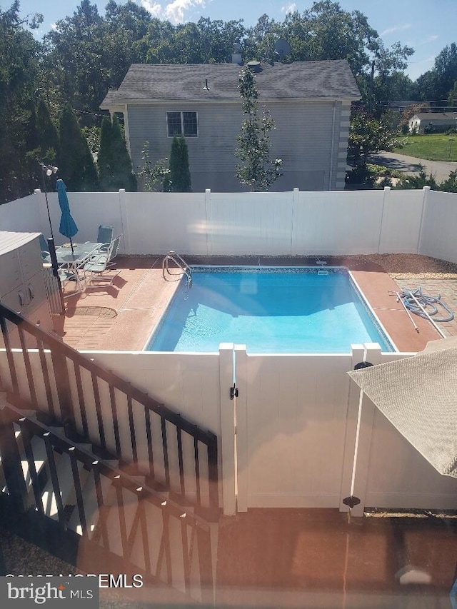 view of pool with a patio area, a fenced in pool, and fence