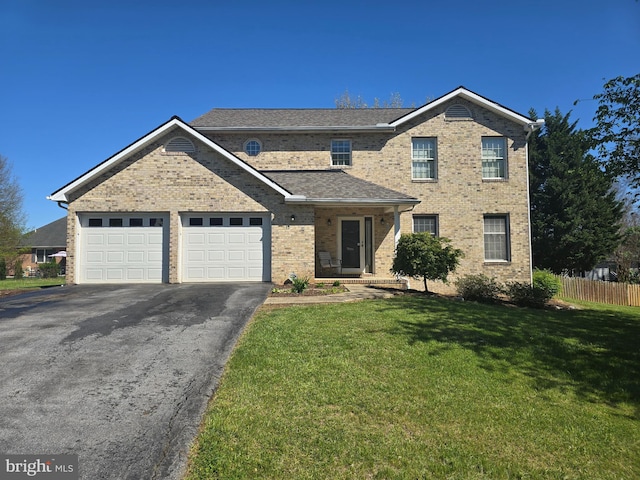 traditional home featuring fence, brick siding, a garage, a front yard, and driveway