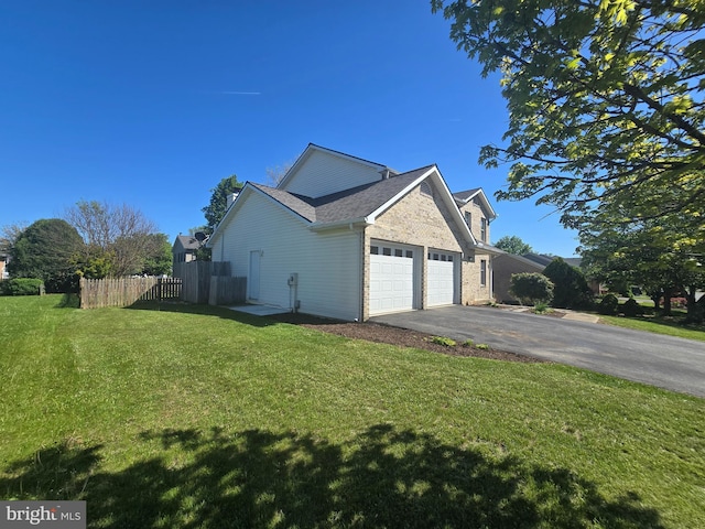 view of side of home featuring a yard, fence, driveway, and a garage