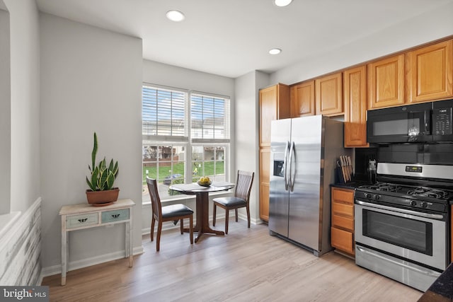 kitchen with recessed lighting, dark countertops, light wood-style flooring, and appliances with stainless steel finishes