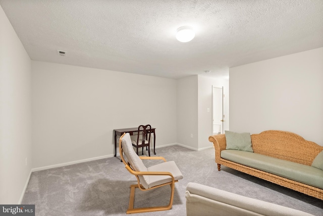 living area with baseboards, visible vents, carpet floors, and a textured ceiling