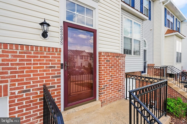 entrance to property featuring brick siding
