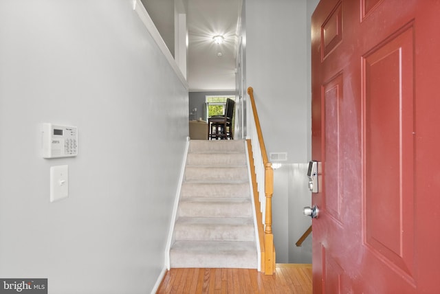 staircase with wood finished floors and baseboards