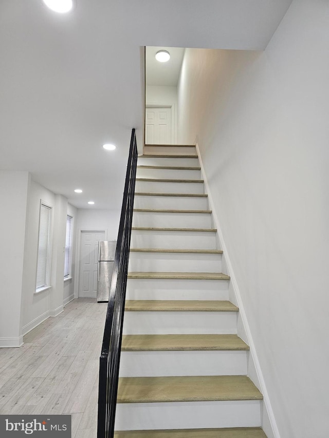 stairway featuring baseboards, recessed lighting, and wood finished floors