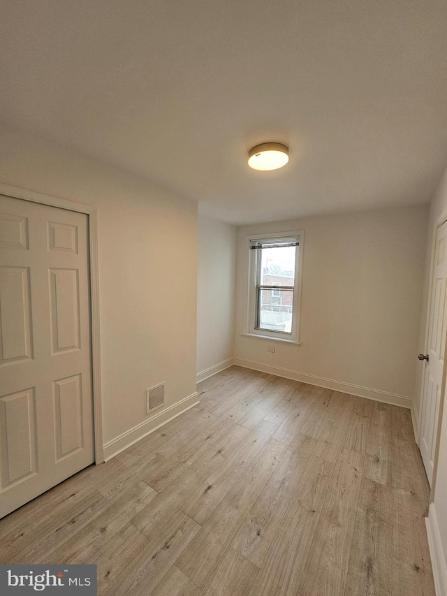 unfurnished room with visible vents, baseboards, and light wood-type flooring