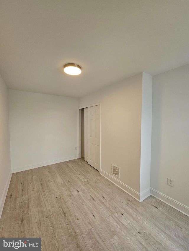 unfurnished room with visible vents, baseboards, and wood finished floors