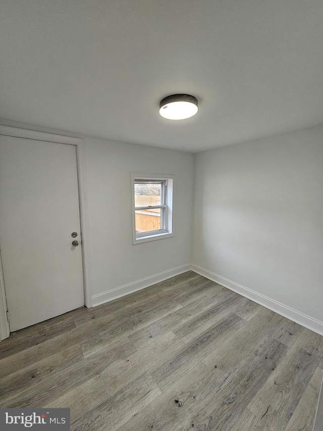 unfurnished room featuring wood finished floors and baseboards