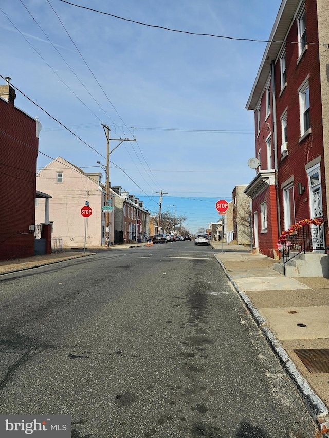 view of street with curbs, street lights, traffic signs, and sidewalks