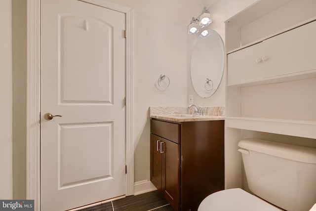 half bathroom featuring vanity and toilet