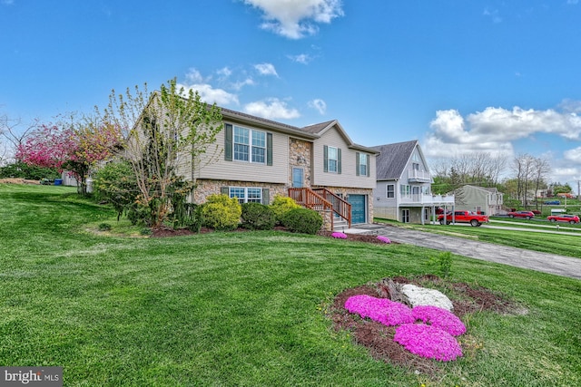 18 Schofield Dr, East Berlin, PA 17316 - split foyer home featuring a front lawn, stone siding, a garage, and aphalt driveway