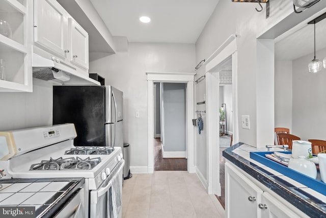 kitchen featuring hanging light fixtures, freestanding refrigerator, white cabinetry, white range with gas stovetop, and recessed lighting
