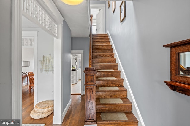 stairway featuring baseboards and wood finished floors