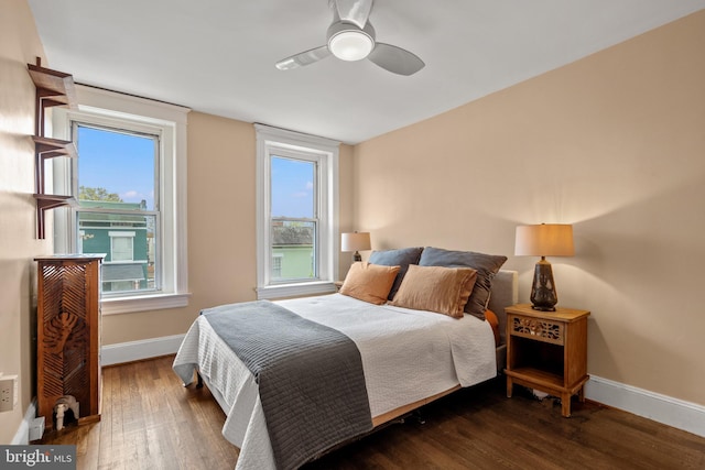 bedroom featuring wood finished floors, ceiling fan, baseboards, and multiple windows