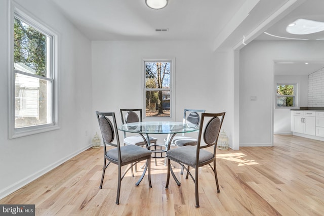 dining space with plenty of natural light, visible vents, light wood-style flooring, and baseboards