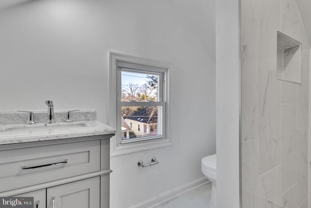 bathroom featuring toilet, marble finish floor, baseboards, and vanity