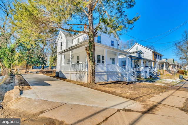 view of front facade with covered porch, central AC unit, and driveway
