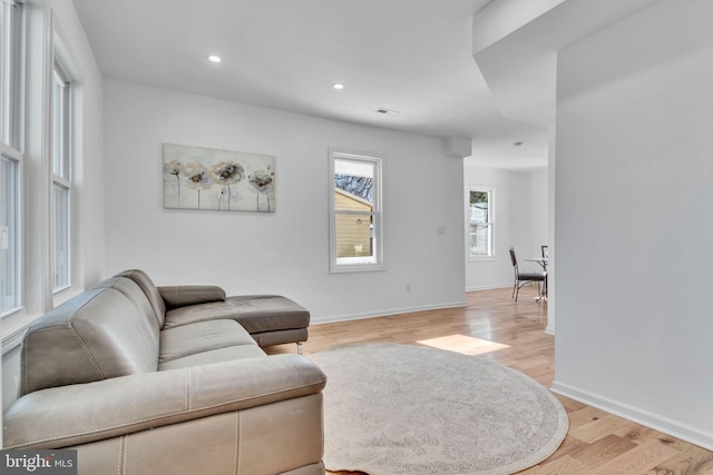 living room featuring light wood-type flooring, baseboards, and recessed lighting