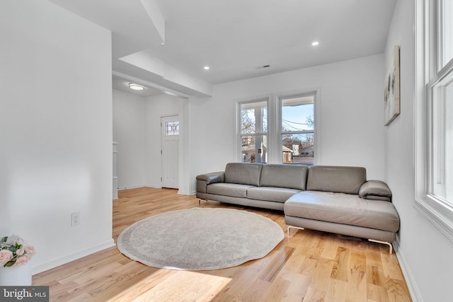 living room featuring baseboards, recessed lighting, and light wood-type flooring