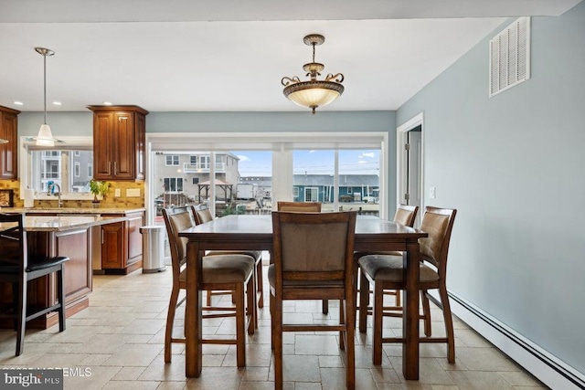 823 Forepeak Dr, Forked River, NJ 08731 - dining area featuring stone tile floors, a baseboard heating unit, visible vents, and plenty of natural light