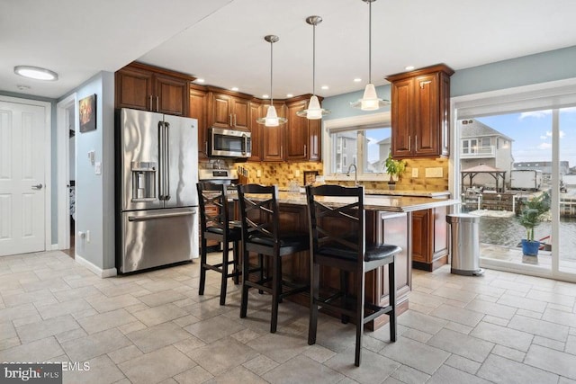 823 Forepeak Dr, Forked River, NJ 08731 - kitchen featuring tasteful backsplash, a center island, a kitchen bar, stainless steel appliances, and stone finish flooring