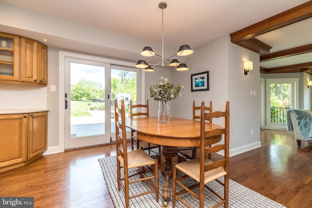 dining room featuring light wood-style floors, a chandelier, and baseboards