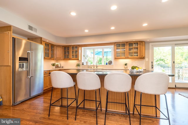kitchen featuring high quality fridge, a sink, recessed lighting, dark wood-style flooring, and brown cabinetry