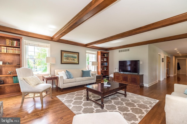 living room with healthy amount of natural light, beamed ceiling, wood finished floors, and baseboards