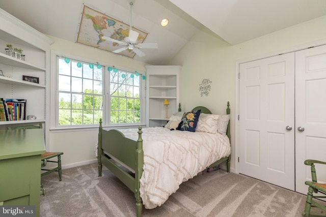 carpeted bedroom with lofted ceiling, baseboards, and a closet